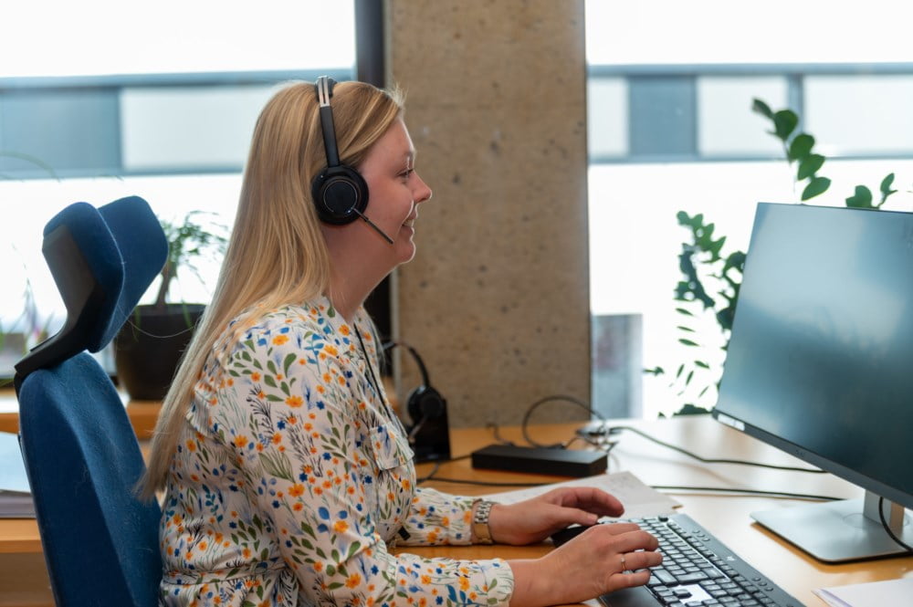 kunderådgiver sitter og snakker i telefon